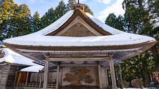 茅葺き屋根に雪を抱いた白山神社能舞台
